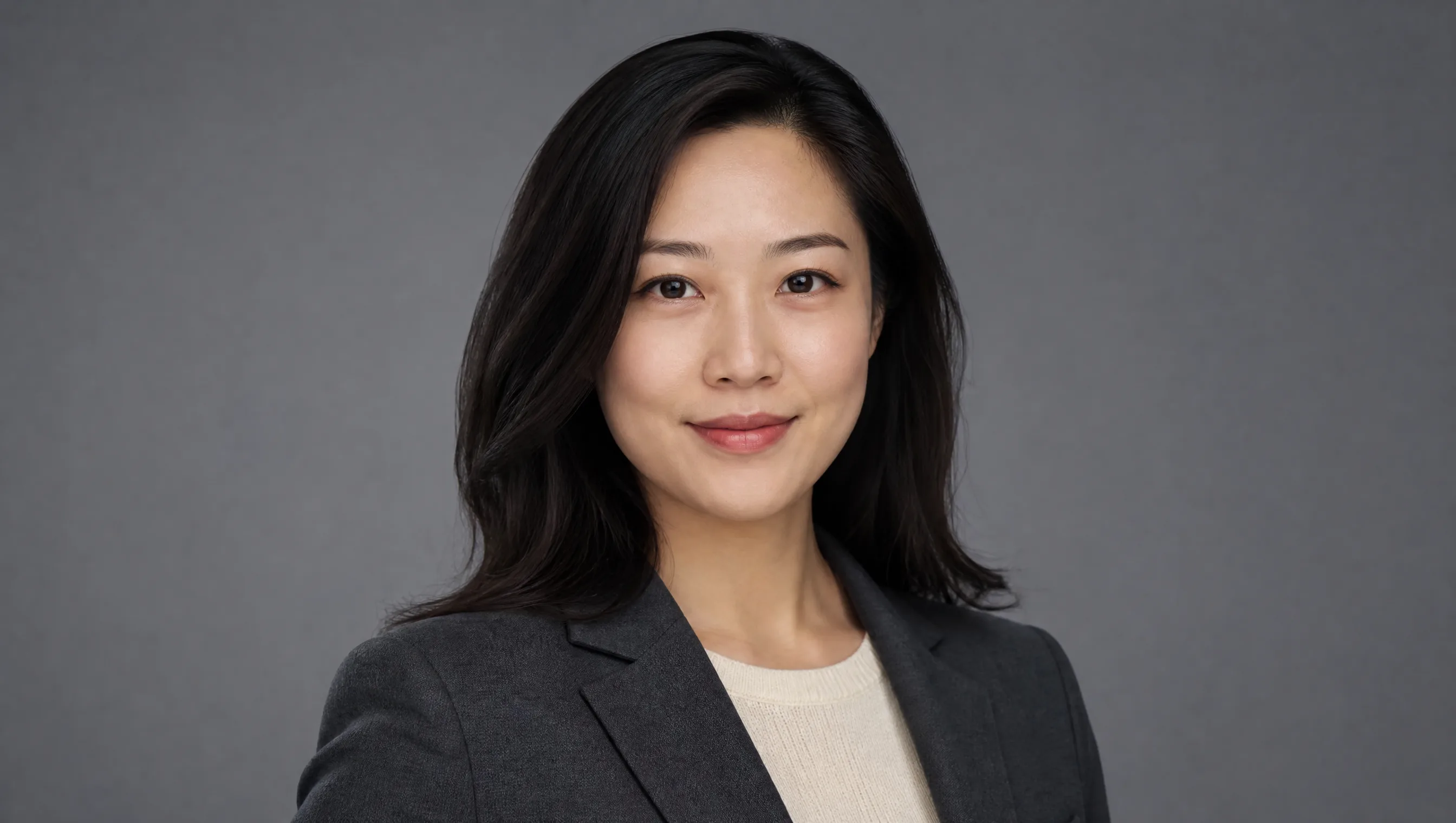 Studio professional headshot of a woman in a charcoal blazer